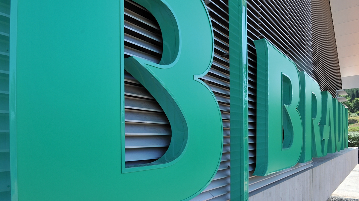 Close-up of a three-dimensional B. Braun logo on the facade of a modern building