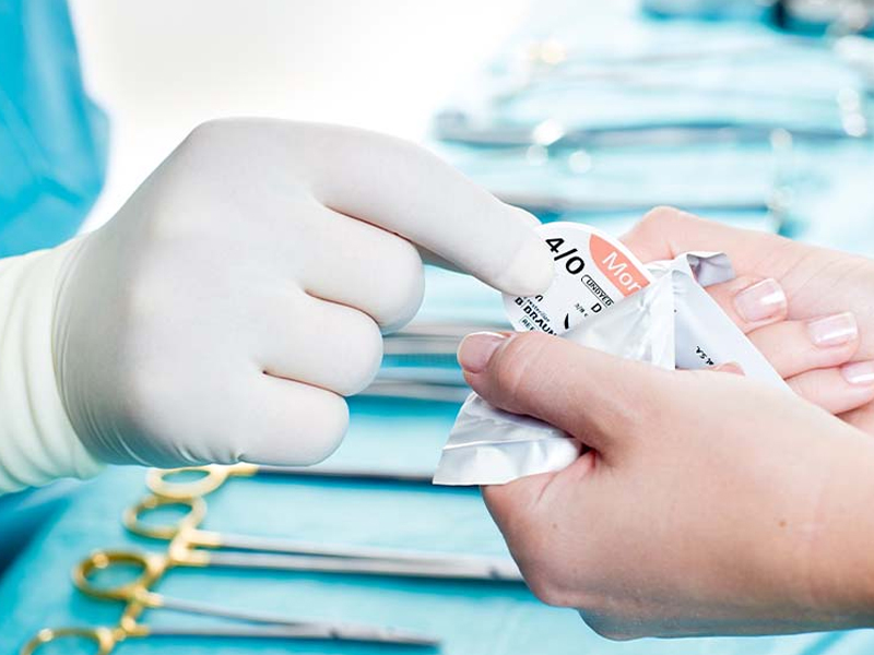 Hands of a medical worker holding a small adhesive bandage for wound care