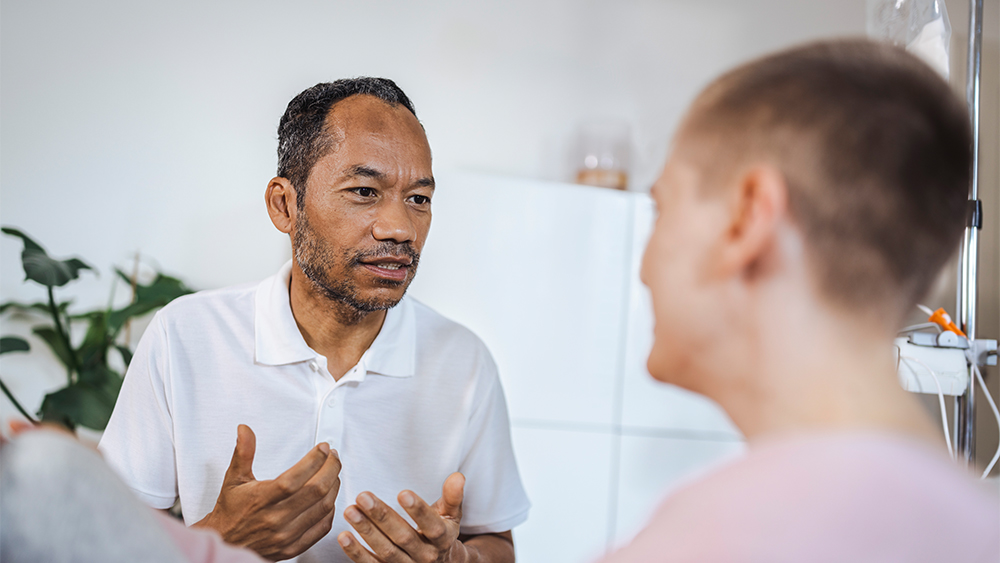 Two patients are having a conversation. One of them appears to be talking with a concerned expression