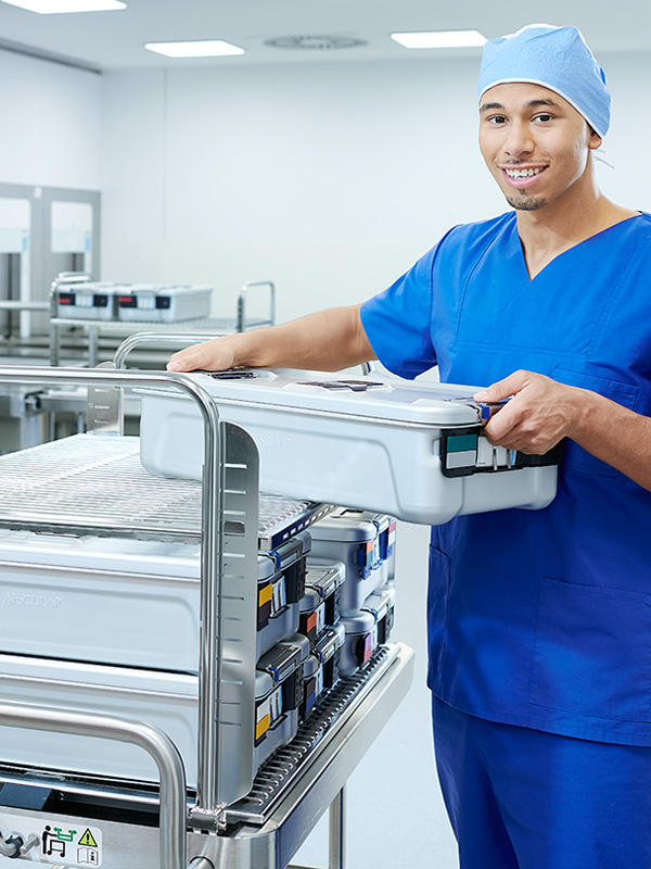 A male healthcare professional is holding a huge container smiling