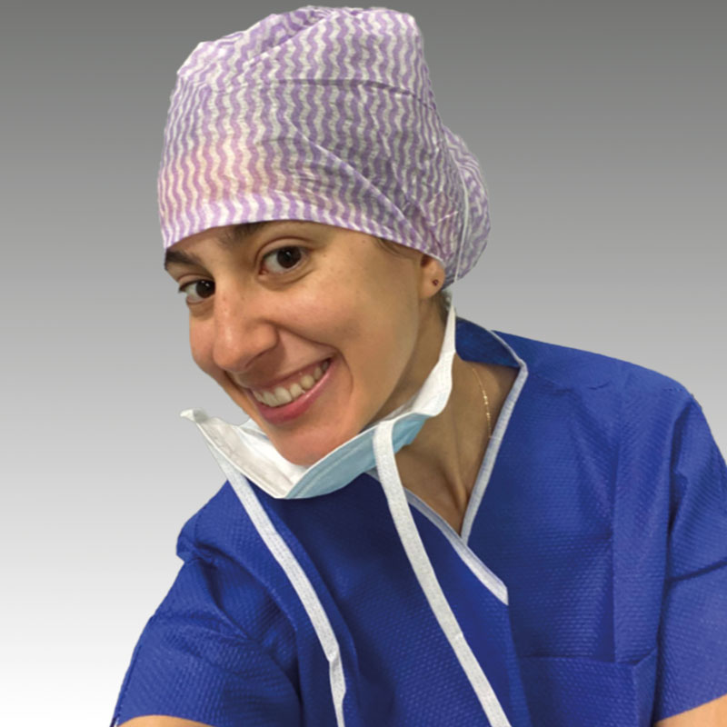 A selfie of Medical Student Sara Cama in surgical clothing smiling into the camera